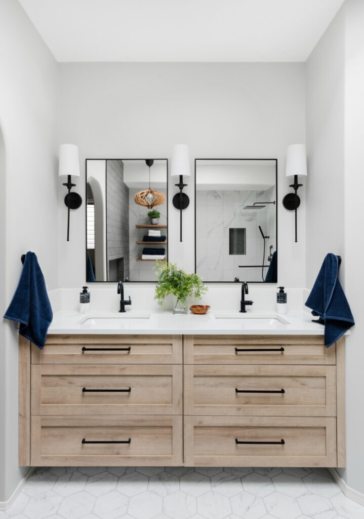 Double vanity with light wood drawers, black fixtures, and clean lines, showing modern bathroom design with a calm, fresh style.