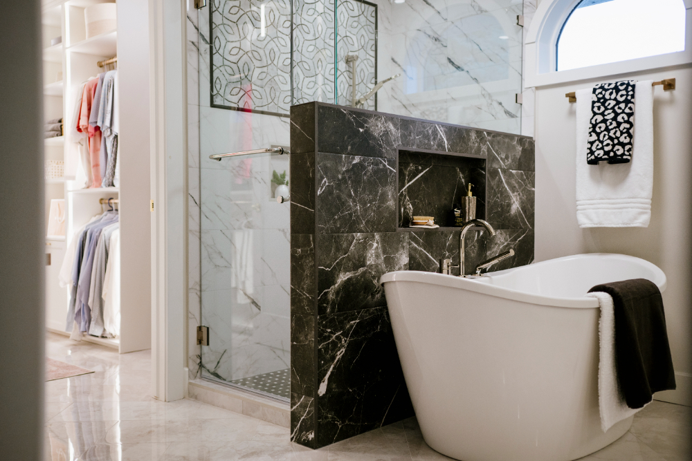 Elegant bathroom with freestanding tub, marble finishes, and glass shower, blending luxury and function—ideal example for interior decorator vs interior designer comparison.