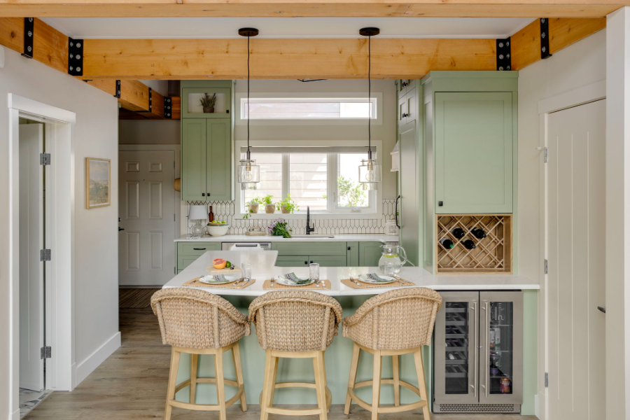 Small kitchen Cottage Club Rocky View County renovation featuring sage green cabinetry, an island with seating, and integrated storage. A great example of how to make a small room look bigger through efficient layout, natural light, and thoughtful space planning.