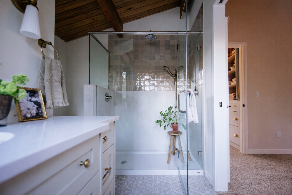 Glass-enclosed shower with mosaic tile under a vaulted wood ceiling, showing the layout choices that affect bathroom renovation cost in Calgary.