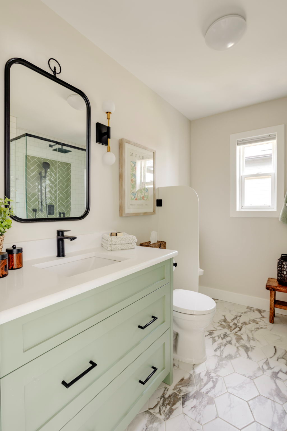 Sage green vanity with black hardware and hexagon marble flooring, illustrating mid-range finishes within a typical bathroom renovation cost in Calgary.