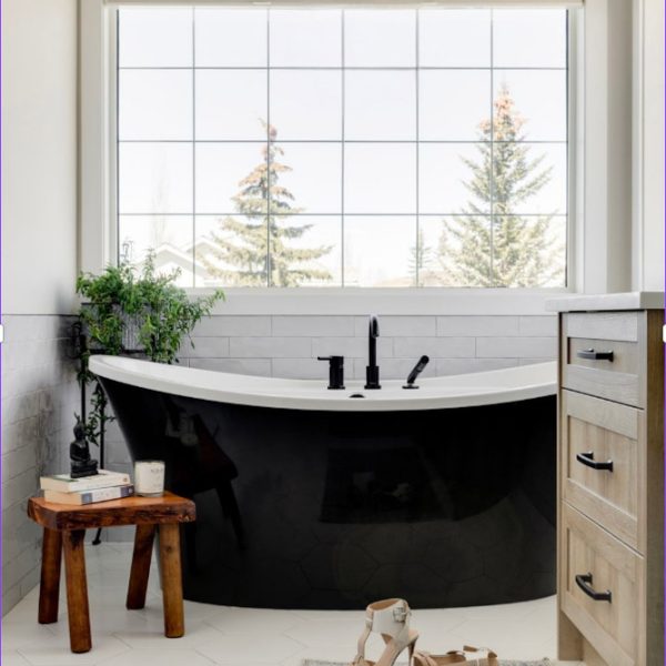 Beautiful black and white soaker tub in farmhouse inspired ensuite.